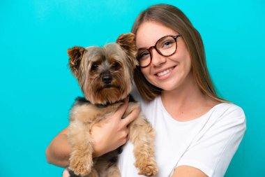 Mavi arka planda köpeği tutan Litvanyalı genç bir kadın.