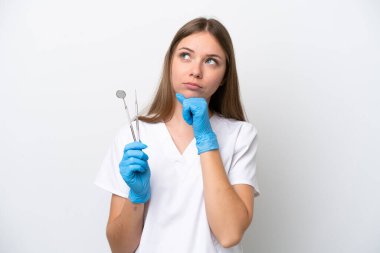 Beyaz arka planda izole edilmiş aletleri tutan dişçi kadın