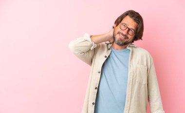 Yaşlı Hollandalı adam pembe arka planda izole edilmiş gülüyor.