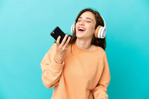Giovane Donna Caucasica Isolata Sfondo Blu Ascoltare Musica Con Cellulare — Foto Stock