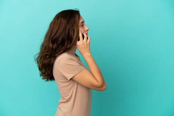 Молодая Белая Женщина Изолированная Синем Фоне Разговаривает Кем Мобильному Телефону — стоковое фото