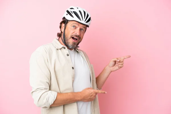 Senior Dutch Man Bike Helmet Isolated Pink Background Surprised Pointing — Stock Photo, Image