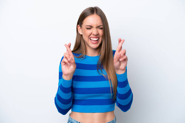 Young caucasian woman isolated on white background with fingers crossing