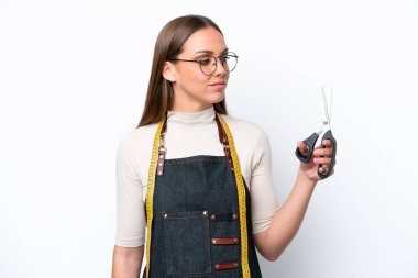Young seamstress woman isolated on white background looking side