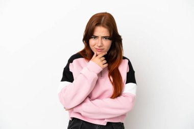 Genç kızıl saçlı kadın beyaz arka planda soyutlanmış düşünüyor.