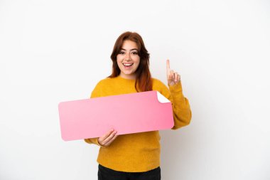 Genç kızıl saçlı kadın beyaz arka planda izole edilmiş, elinde boş bir pankart var.