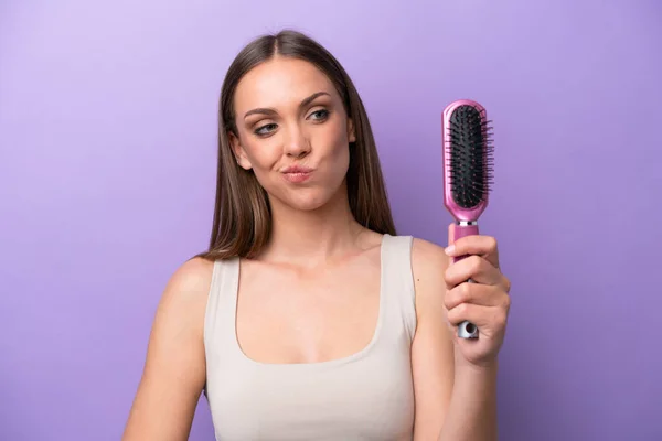 Joven Mujer Caucásica Sosteniendo Cepillo Aislado Sobre Fondo Púrpura Con —  Fotos de Stock