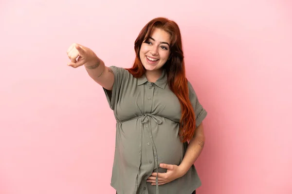 Young Redhead Caucasian Woman Isolated Pink Background Pregnant Pointing Front — ストック写真