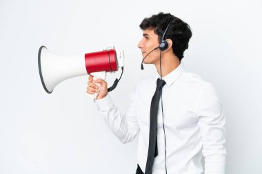 Tele pazarlamacı beyaz arka planda izole edilmiş bir kulaklıkla çalışıyor. Megafonla bağırıyor.