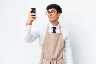 Arjantinli bir restoran garsonu beyaz arka planda izole edilmiş bir selfie çekiyor.