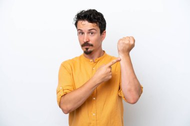 Bıyıklı genç adam beyaz arka planda izole edilmiş, geç kalma jesti yapıyor.