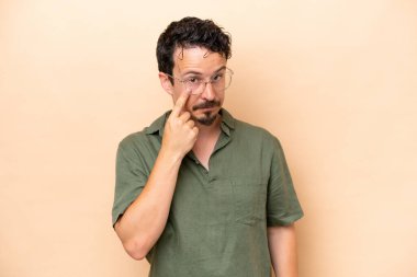 Beyazlı genç bir adam bej arka planda izole edilmiş.