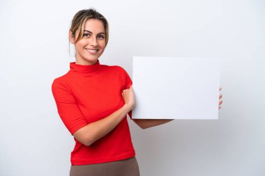 Beyaz arka planda izole edilmiş beyaz bir kadın elinde mutlu bir ifadeyle boş bir levha tutuyor.