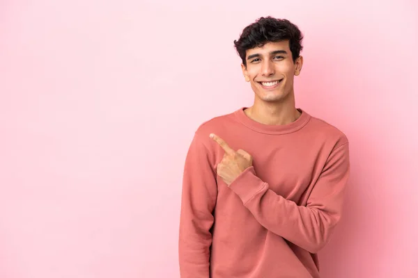 Jonge Argentijnse Man Geïsoleerd Roze Achtergrond Wijzend Naar Zijkant Een — Stockfoto