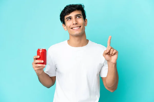 Jonge Argentijnse Man Houdt Een Verfrissing Geïsoleerd Blauwe Achtergrond Wijzend — Stockfoto