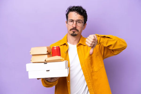 Young Caucasian Man Holding Fast Food Isolated Purple Background Showing — Foto de Stock