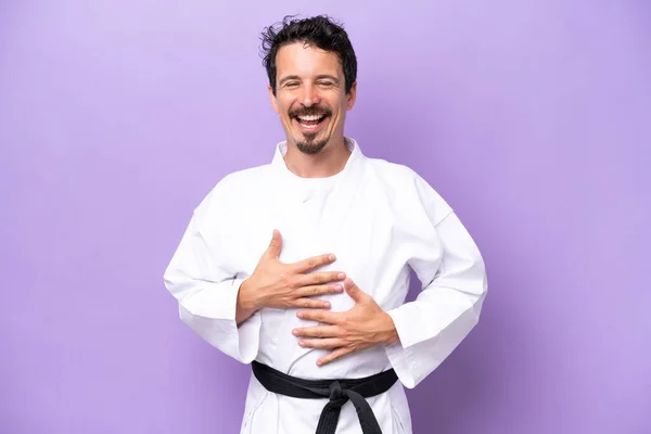Joven Hombre Caucásico Haciendo Karate Aislado Sobre Fondo Púrpura Sonriendo — Foto de Stock
