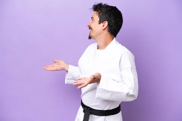 Joven Hombre Caucásico Haciendo Karate Aislado Sobre Fondo Púrpura Con —  Fotos de Stock