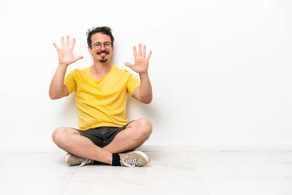 Young Caucasian Man Sitting Floor Isolated White Background Counting Ten - Stock-foto