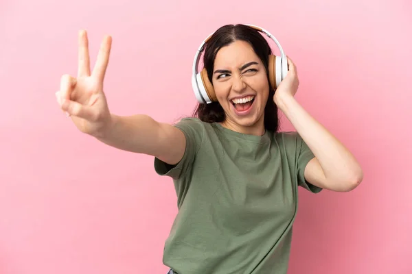 Joven Mujer Caucásica Aislada Sobre Fondo Rosa Escuchando Música Cantando —  Fotos de Stock