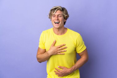 Soyutlanmış mor arka plandaki İngiliz adam gülümsüyor.