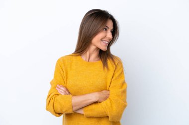 Beyaz arka planda soyutlanmış, kolları çapraz ve mutlu orta yaşlı beyaz bir kadın.