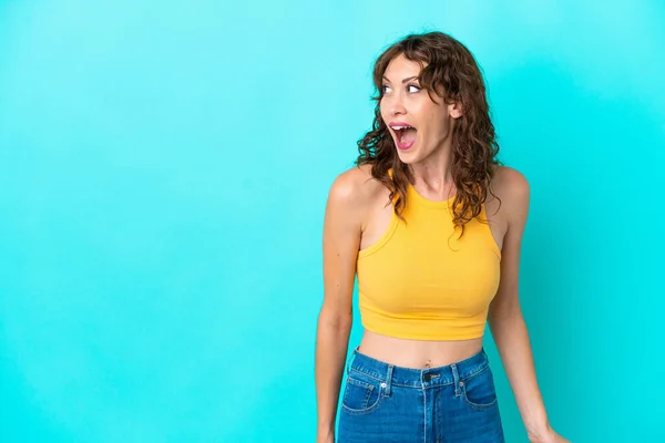 Young Woman Curly Hair Isolated Blue Background Doing Surprise Gesture — Φωτογραφία Αρχείου