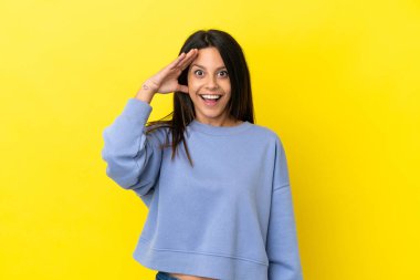 Sarı arka planda izole genç beyaz kadın bir şey fark etti ve çözüme niyetlendi.