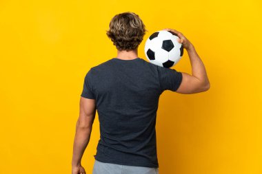 İngiliz adam futbol topuyla izole edilmiş sarı arka plan