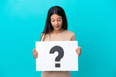 İzole edilmiş arka plan üzerinde soru işareti olan bir pankart tutan genç bir kadın.