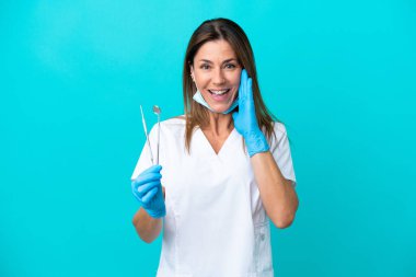 Middle age doctor woman isolated on blue background shouting with mouth wide open