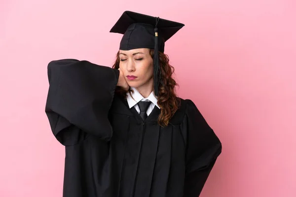 Young university graduate woman isolated on pink background with neckache
