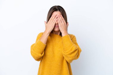 Orta yaşlı beyaz kadın, beyaz arka planda izole edilmiş. Gözlerini elleriyle kapatıyor.