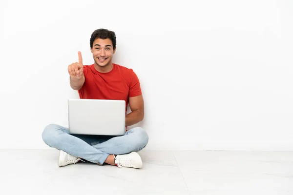 Caucasian Handsome Man Laptop Sitting Floor Showing Lifting Finger — Φωτογραφία Αρχείου