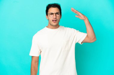 Yorgun ve hasta ifade ile izole mavi arka plan üzerinde Kafkas yakışıklı adam