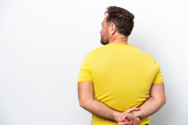 Orta yaşlı beyaz bir adam beyaz arka planda izole edilmiş ve arkasına bakıyor.