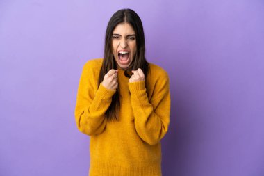 Mor arka planda izole edilmiş genç beyaz kadın kötü bir durum yüzünden hayal kırıklığına uğradı.