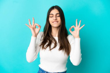 Zen pozunda mavi arka planda izole edilmiş beyaz bir kadın.
