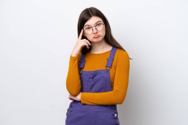 Genç Rus kadın mavi arka planda bir fikir düşünerek izole edildi.