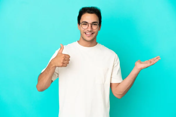 Caucasian Handsome Man Isolated Blue Background Holding Copyspace Imaginary Palm — Stock Fotó