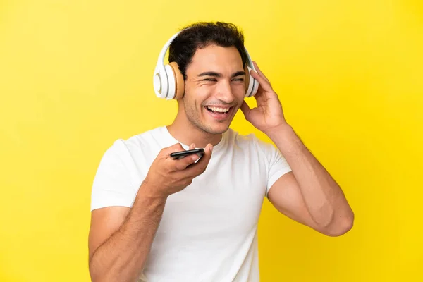 Caucasian Handsome Man Isolated Yellow Background Listening Music Mobile Singing — Φωτογραφία Αρχείου
