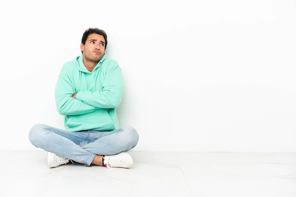 Caucasian Handsome Man Sitting Floor Making Doubts Gesture While Lifting — Stock fotografie