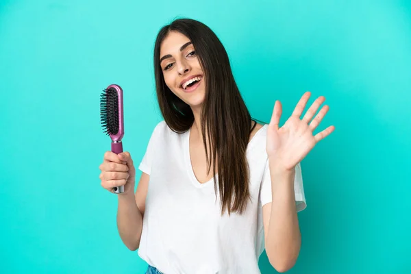Young Caucasian Woman Hair Comb Isolated Blue Background Saluting Hand —  Fotos de Stock