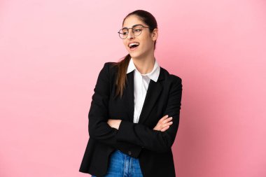 Genç beyaz iş kadını pembe arka planda izole edilmiş mutlu ve gülümsüyor.