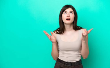 Young Russian woman isolated on green background stressed overwhelmed