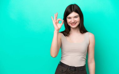 Young Russian woman isolated on green background showing ok sign with fingers