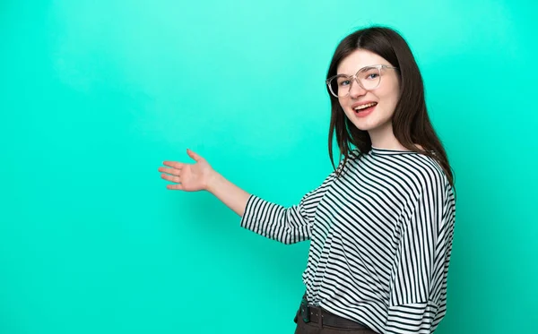 Jonge Russische Vrouw Geïsoleerd Groene Achtergrond Reiken Handen Naar Zijkant — Stockfoto