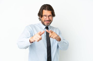 Üst düzey Hollandalı iş adamı beyaz arka planda izole edilmiş, ön tarafı işaret ediyor ve gülümsüyor.
