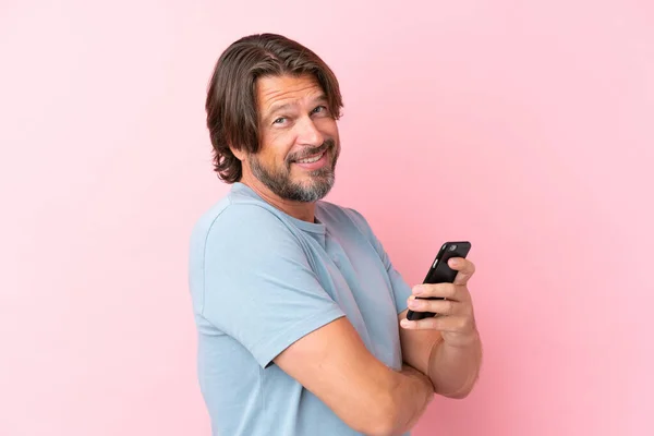 Senior Dutch Man Isolated Pink Background Holding Mobile Phone Arms — ストック写真