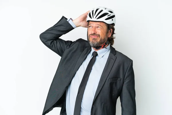 Business senior man with a bike helmet isolated on white background having doubts and with confuse face expression